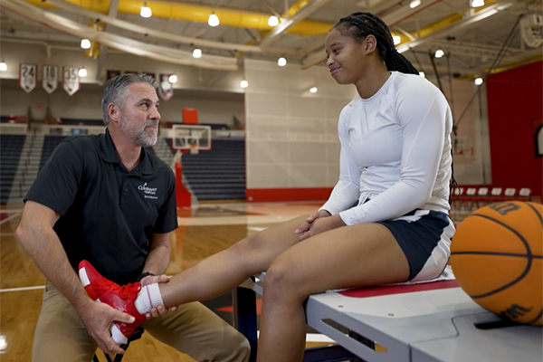 Dr Purchase assisting an SVSU basketball player